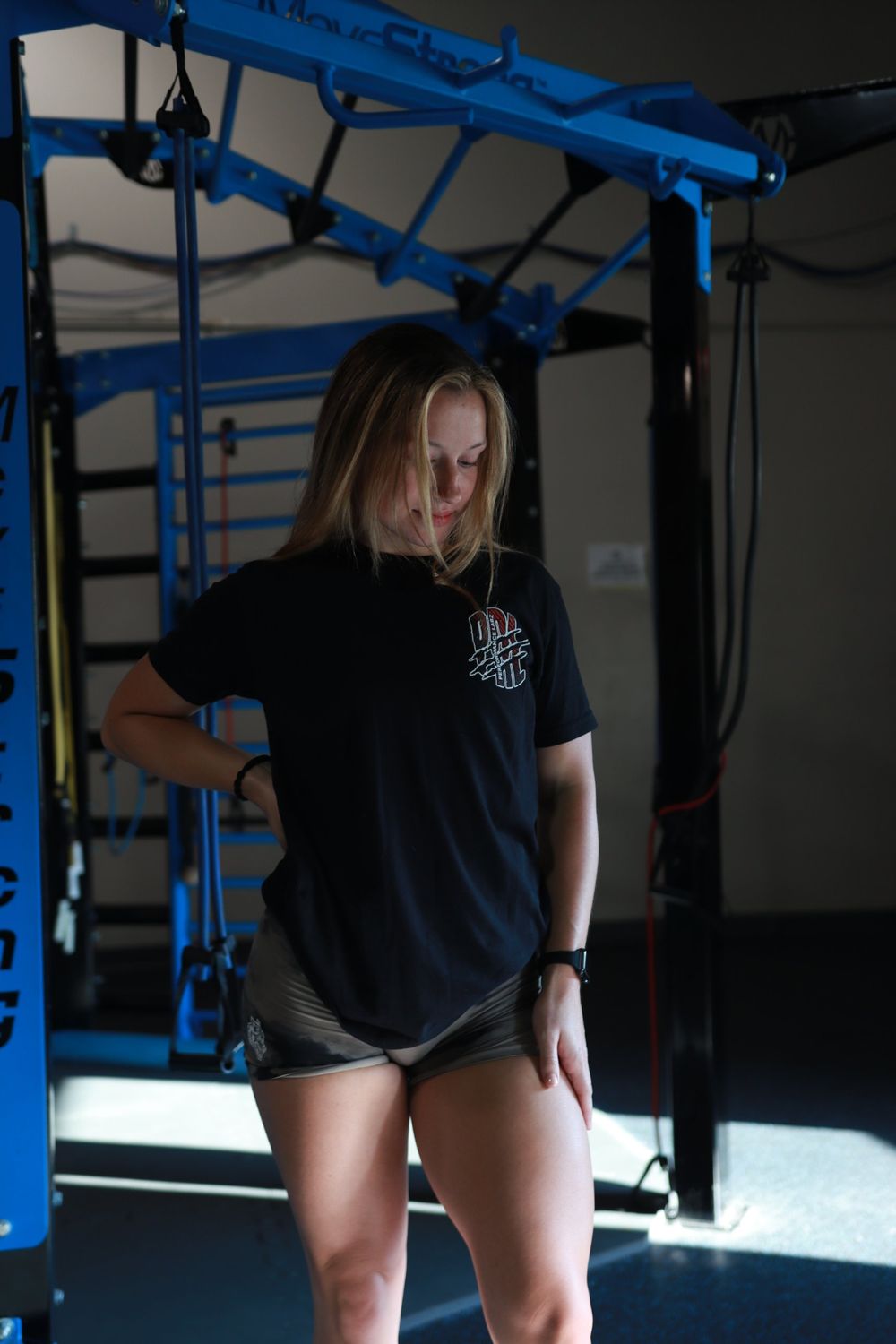 Athlete in a black graphic tee standing in a gym rig